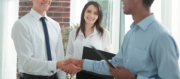 Handshake of young business partners in the office