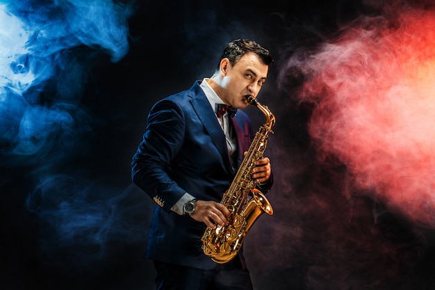 Handsome adult man playing saxophone