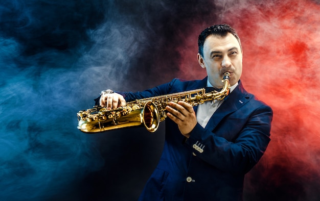 Handsome adult man playing saxophone