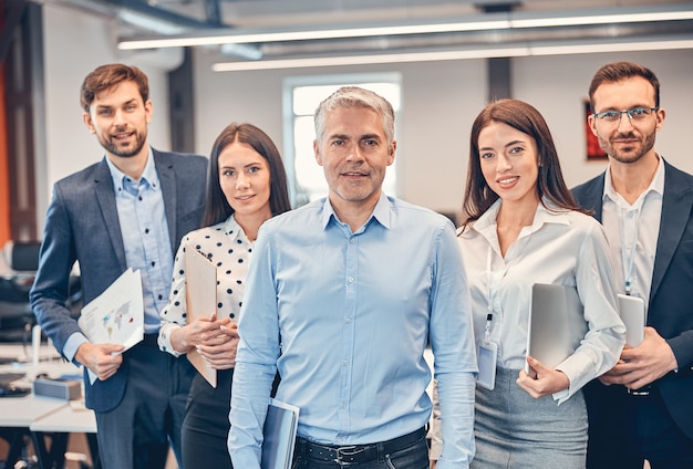 Handsome adult man with his professional team in the office