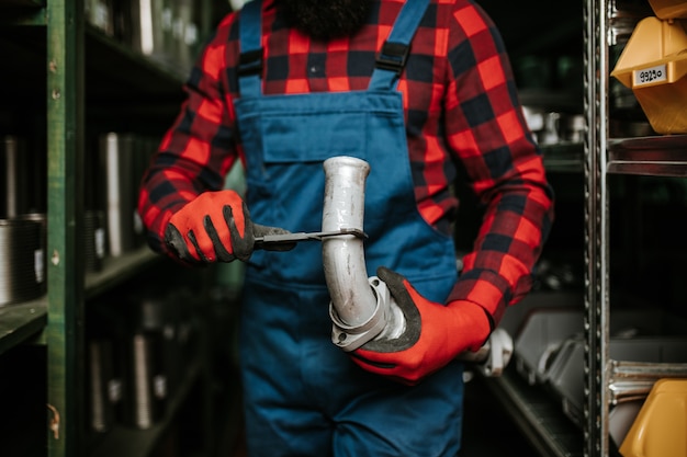 Handsome adult man working in car and truck spare parts warehouse.