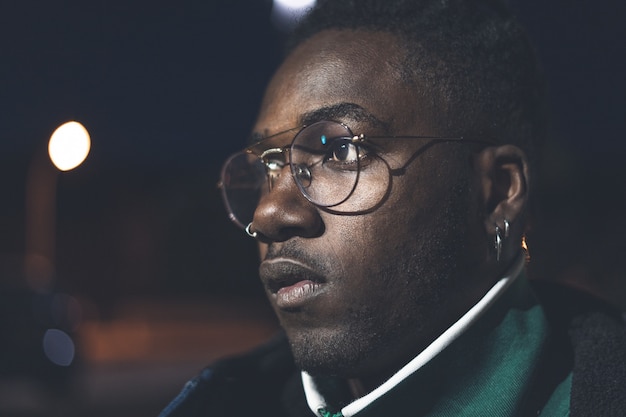 Photo handsome african-american guy with street glasses. black man serious