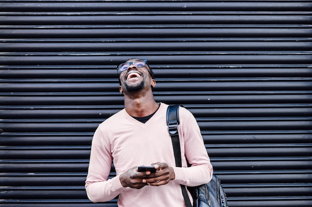 Handsome African American man smiling with smartphone