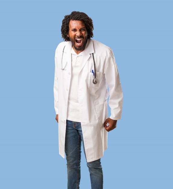 Handsome african american medical doctor screaming angry, expression of madness