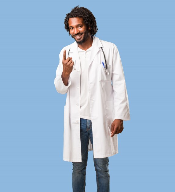 Handsome african american medical doctor showing number one, symbol of counting