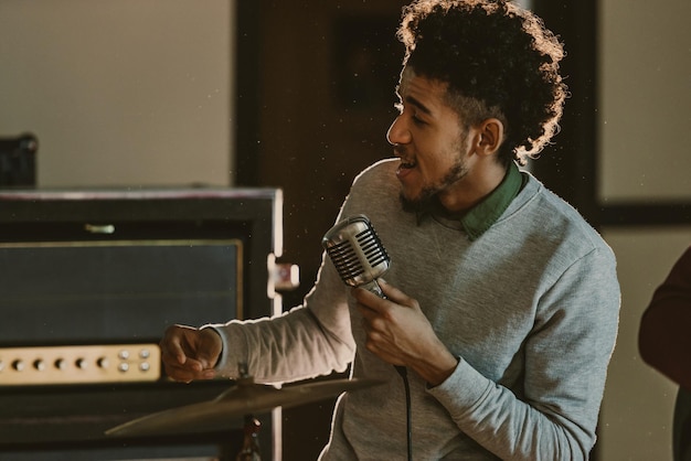 Handsome african american singer performing song with microphone