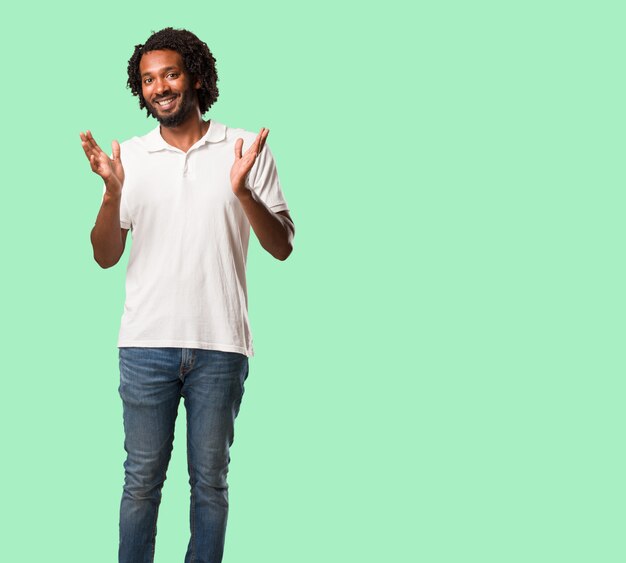 Handsome african american surprised and shocked, looking with wide eyes, excited by an offer or by a new job, win concept