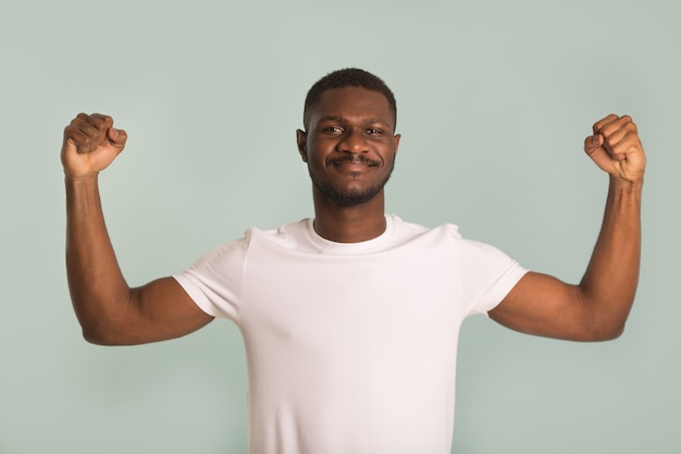 handsome african man in white t-shirt showing his strength