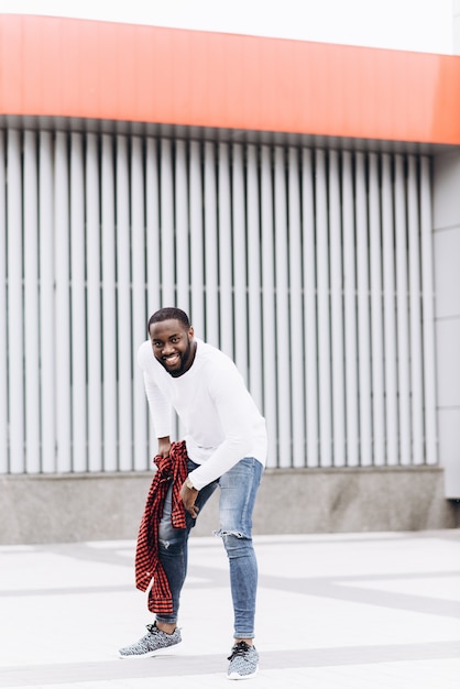 Foto afro americano bello che indossa abiti casual nella città moderna