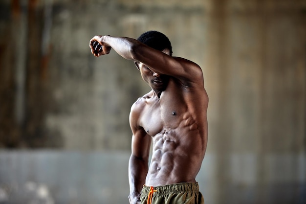 Handsome afro American sportman standing on the street while taking break after training Black male having rest after workout