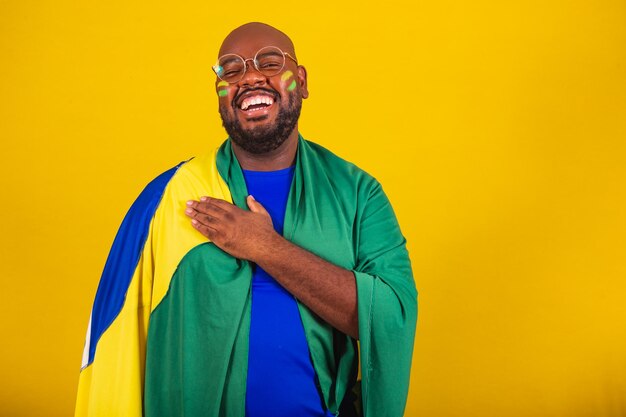 Handsome afro brazilian man wearing glasses brazilian fan\
brazil world cup 2022 hand to chest singing anthem is born\
brazilian music beloved homeland patriot