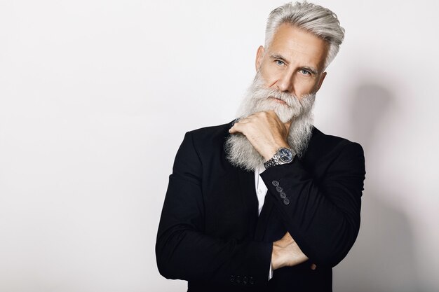 Foto uomo invecchiato bello che porta vestito nero alla moda su bianco