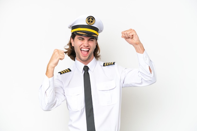 Handsome Airplane pilot isolated on white background celebrating a victory