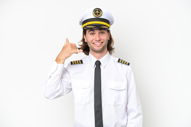 Handsome airplane pilot isolated on white background making\
phone gesture call me back sign