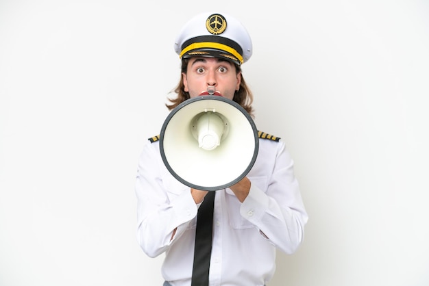 Handsome Airplane pilot isolated on white background shouting through a megaphone