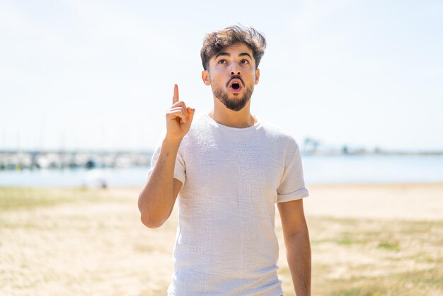 Handsome Arab man at outdoors thinking an idea pointing the finger up