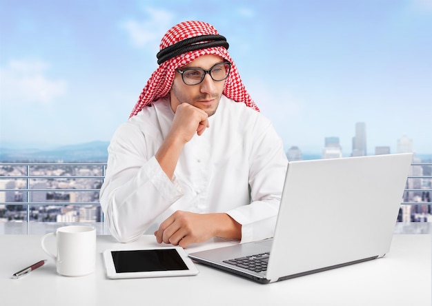 Handsome arab man working with laptop at office