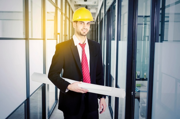 Handsome architect looks confident with his blueprint