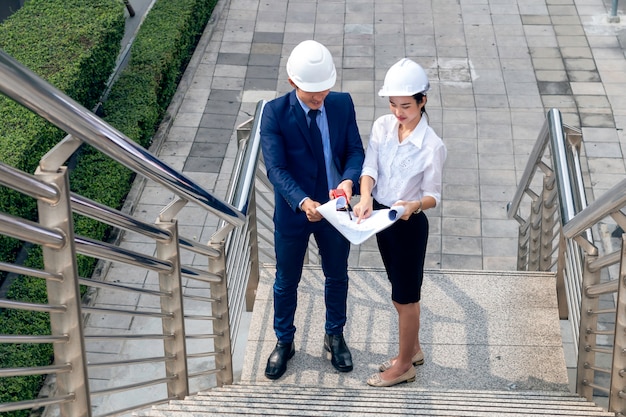 Ingegnere aziendale asiatico bello della donna del responsabile che sorride e che parla del lavoro di successo con i soci.