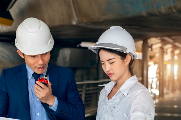 Ingegnere aziendale asiatico bello della donna del responsabile che sorride e che parla del lavoro di successo con i soci.