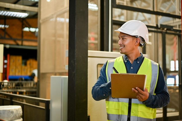 Handsome asian male warehouse manager checking an inventory\
list on paper working in warehouse