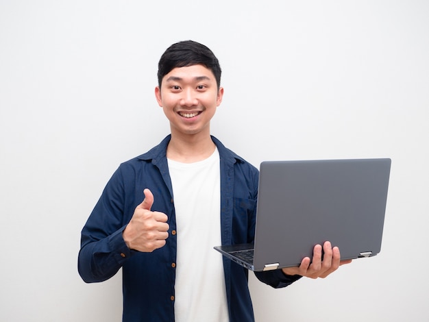 Handsome Asian man blue shirt hold laptop in hand and thumb up with happy smile