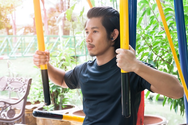 Bel uomo asiatico che esercita nel parco pubblico