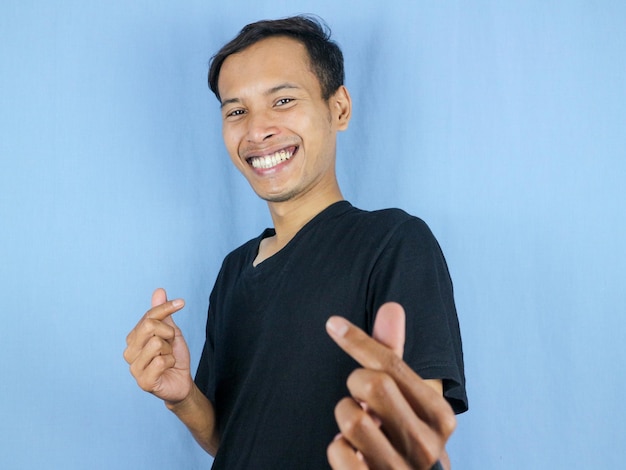 Photo handsome asian man is making a heart shape symbol with his fingers love and romantic concept