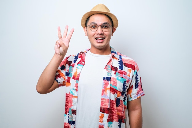 Handsome asian man showing and pointing up with fingers number while smiling confident and happy