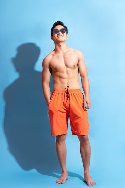 Handsome asian man with bare body on blue