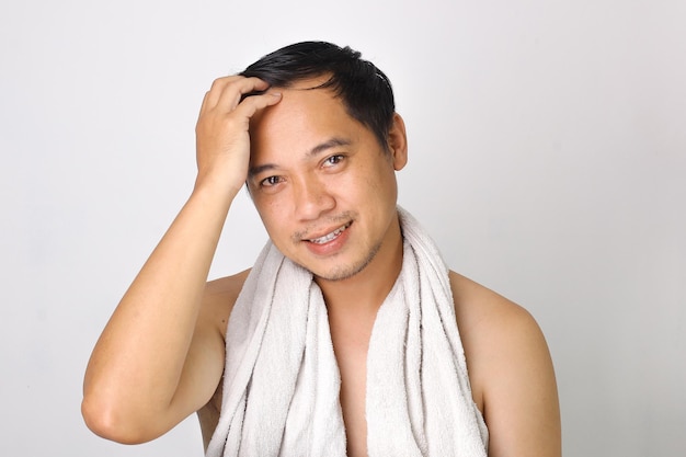 Handsome asian man with his bathroom towel on shoulders