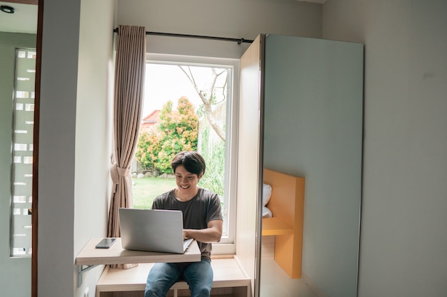 Handsome asian modern man designer working home using laptop at home