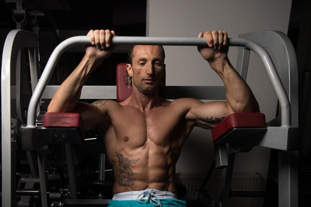 Handsome Athlete Doing Heavy Weight Exercise For Back On Machine