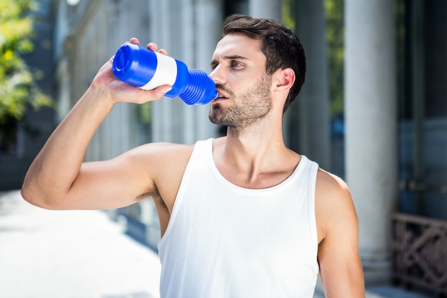 Handsome athlete drinking out of bottle