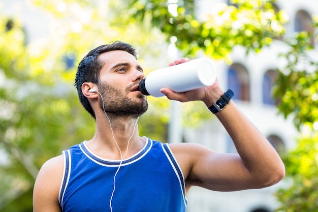 an handsome athlete drinking water