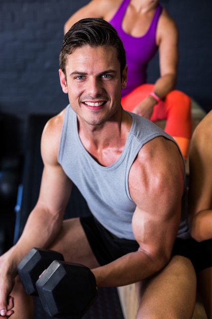 Handsome athlete exercising with dumbbell