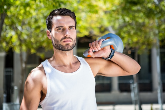 Kettlebell와 잘 생긴 선수 복장