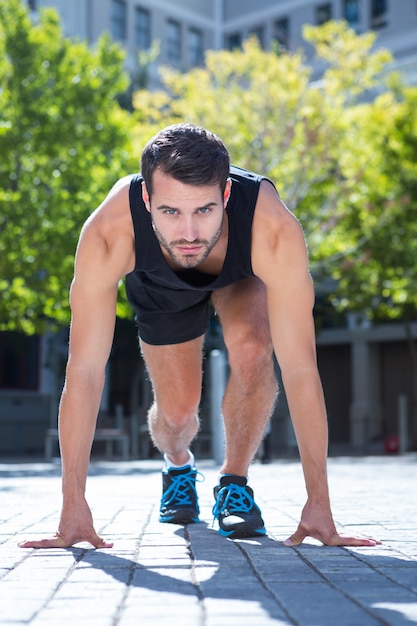 Handsome athlete in running stance