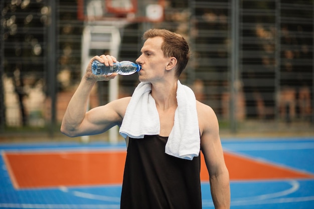 Handsome athlete taking break during outdoors workout