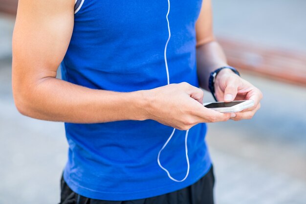 A handsome athlete using his phone