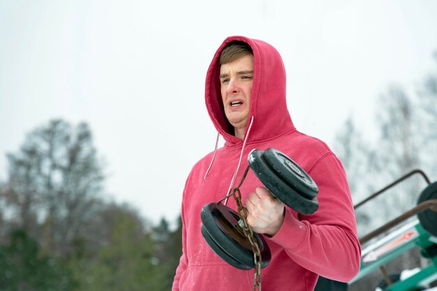 Foto atleta atletico bello dell'uomo di forma fisica che tende il ragazzo di sport che fa allenamento che esercita i muscoli con du