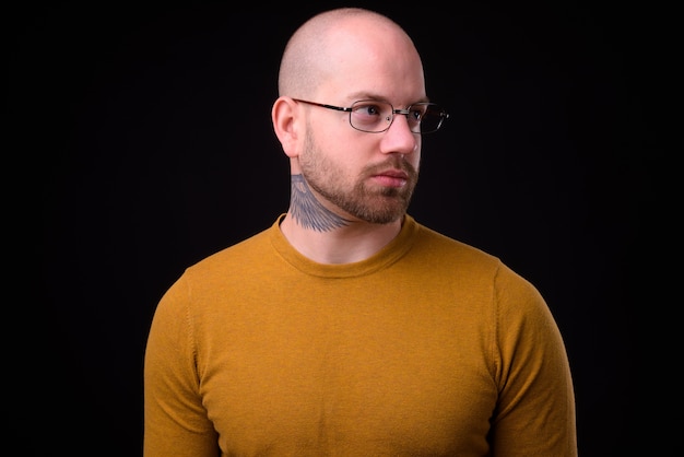 handsome bald bearded man against black space