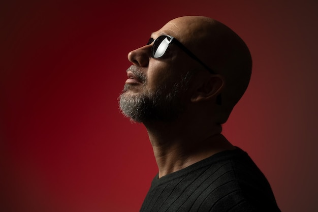 Handsome bald and bearded man in sunglasses serious and confident posing for photo