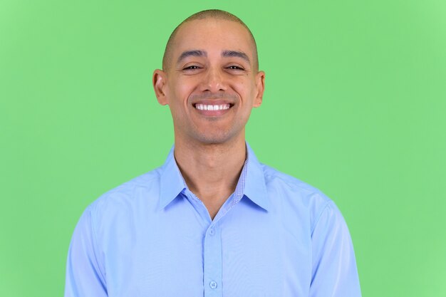 Photo handsome bald multi ethnic businessman against green wall