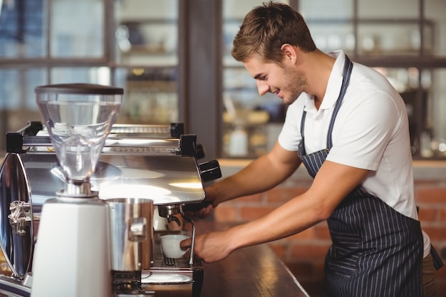 Handsome barista making a cup of coffee