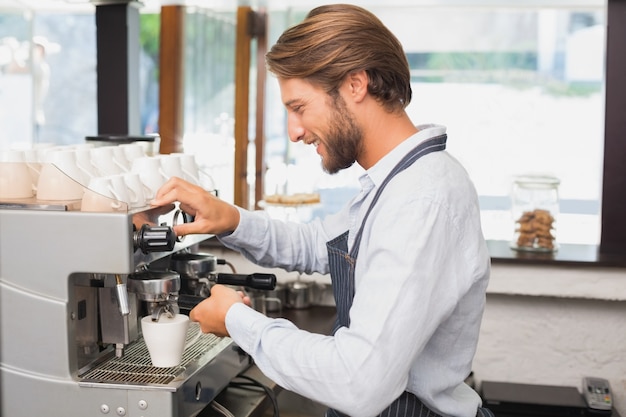 Handsome barista making a cup of coffee