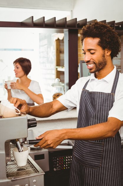 Handsome barista making a cup of coffee