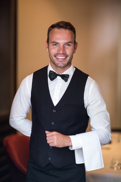 Handsome barman having a towel over his arm