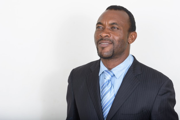 handsome bearded African businessman against white wall