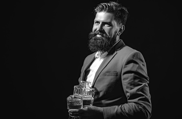 Handsome bearded businessman is drinking expensive whisky